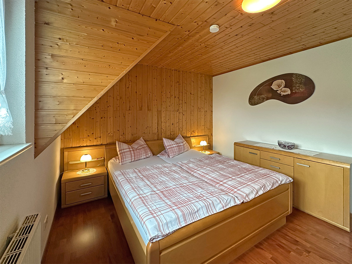 Schlafzimmer mit Holzvertäfelung und Doppelbett