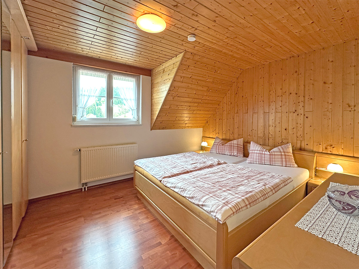 Schlafzimmer mit Holzvertäfelung und Doppelbett